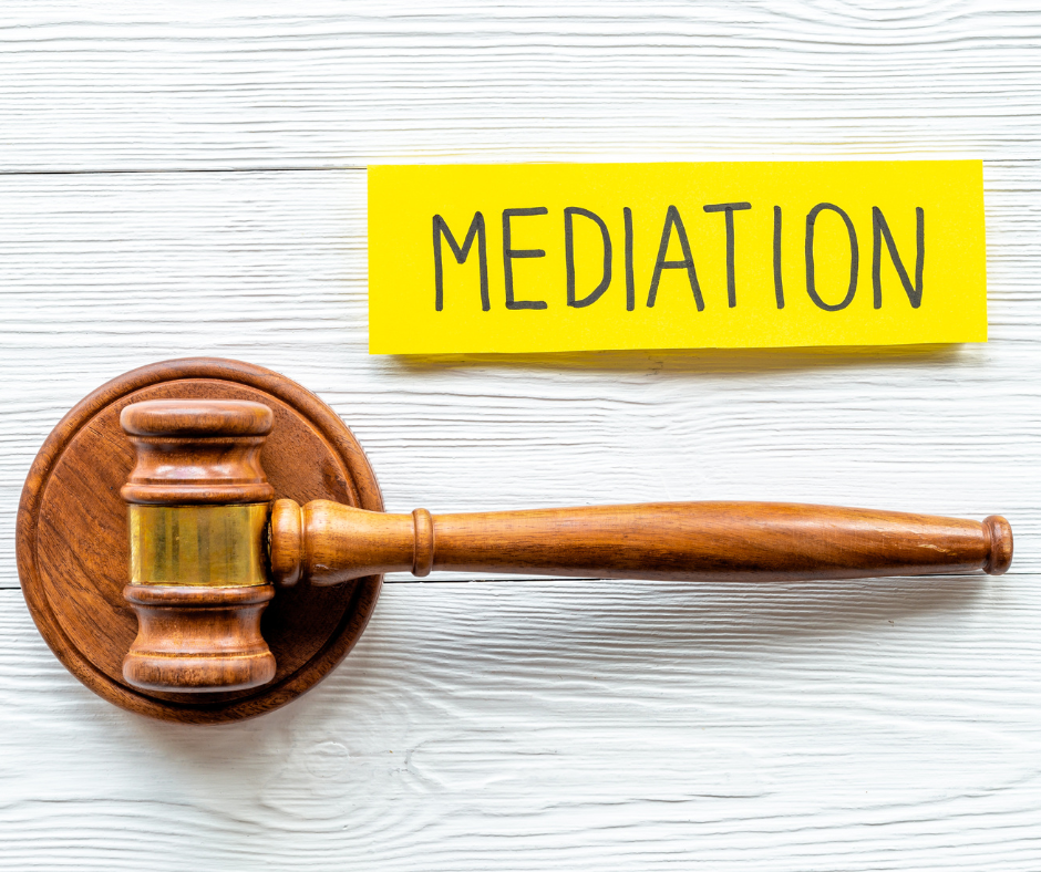 A wooden gavel rests beside a yellow card labeled "MEDIATION," symbolizing new beginnings that can arise through a mediation program, all set on a white wooden surface.